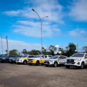 Viaturas estacionadas em fileira sob um céu azul
