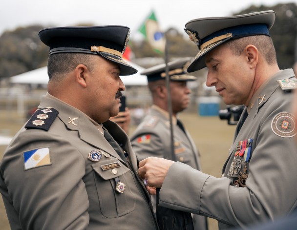 Comandante-Geral da BM entrega medalha a oficial em destaque.