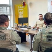Brigadianos aparecem de costas e em frente ao prefeito de Cidreira durante a reunião na sala do Executivo Municipal 