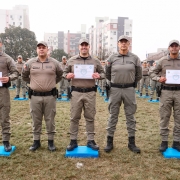 Foto mostra concluintes segurando certificados de láurea