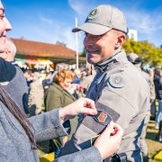 Foto mostra soldado recebendo distintivo de uma familiar.