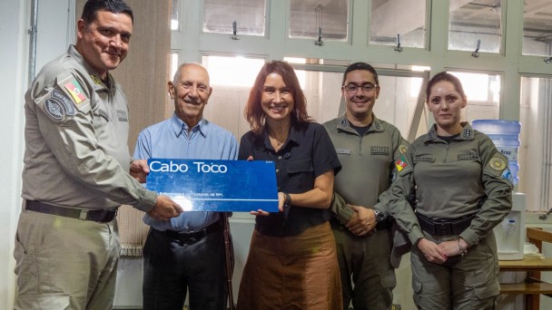 Foto mostra o comandante-geral da BM, coronel Luigi, ao lado de outros oficiais e ex-oficiais da BM, segurando a placa da Rua Cabo Toco