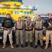 Foto mostra tr&ecirc;s policiais militares da BM ladeados por dois PRFs