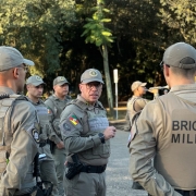 Subcomandante-Geral da BM rodeado de v&aacute;rios policiais militares