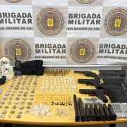 Materiais apreendidos durante a opera&ccedil;&atilde;o: armas, celulares, por&ccedil;&otilde;es diversas de drogas, todos dispostos em mesa.