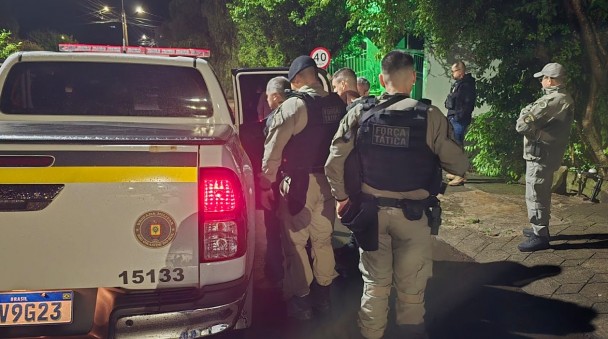 Viatura estacionada com PMs em volta durante a ocorrência.